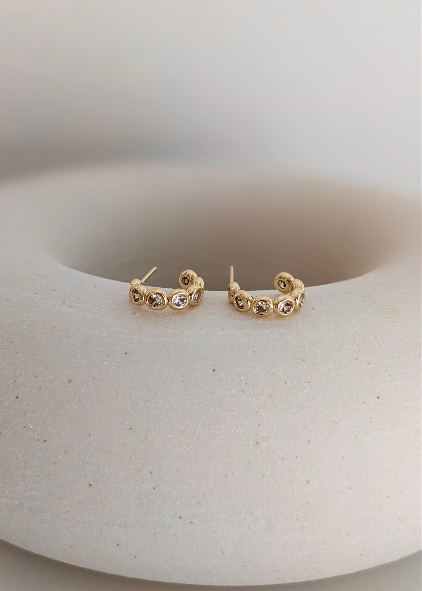 Gold-filled bezel huggie hoops with sparkling cubic zirconia. A comfortable everyday CZ huggie for stacking or wearing solo. Handmade in Brooklyn.