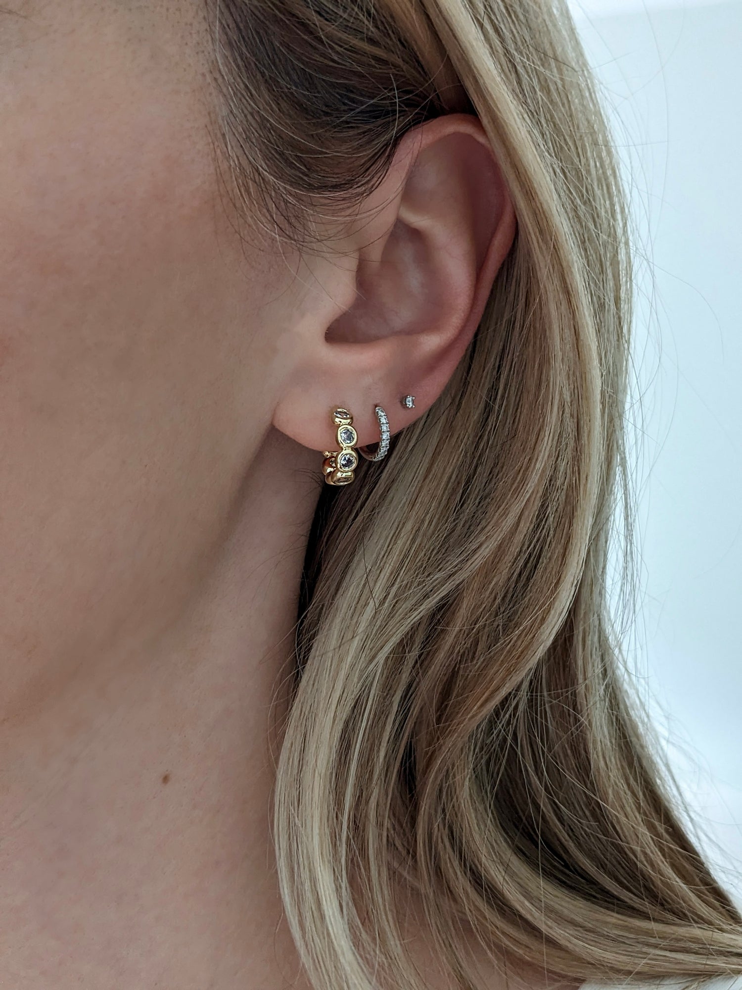 Gold-filled bezel huggie hoops with sparkling cubic zirconia. A comfortable everyday CZ huggie for stacking or wearing solo. Handmade in Brooklyn.
