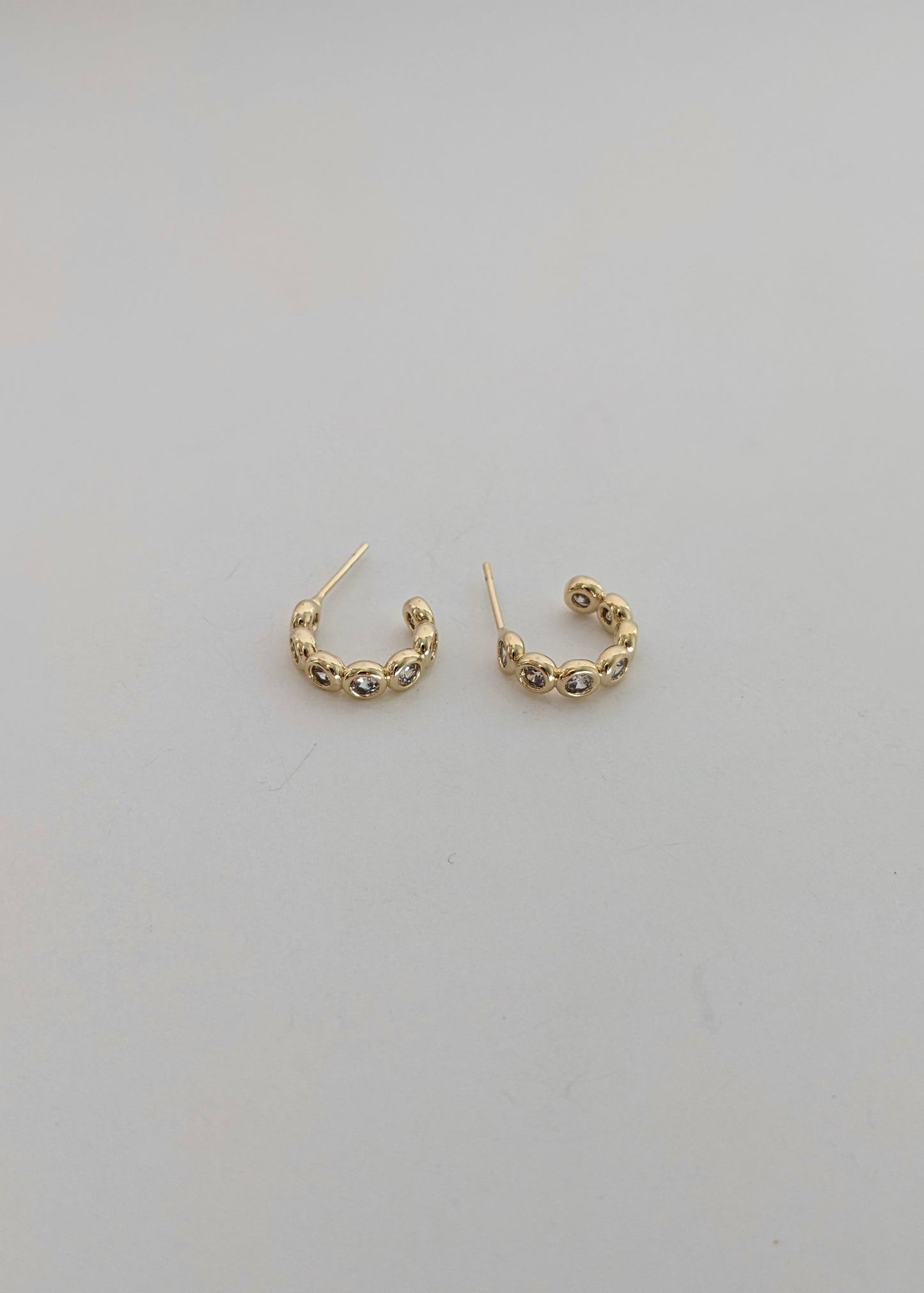 Gold-filled bezel huggie hoops with sparkling cubic zirconia. A comfortable everyday CZ huggie for stacking or wearing solo. Handmade in Brooklyn.
