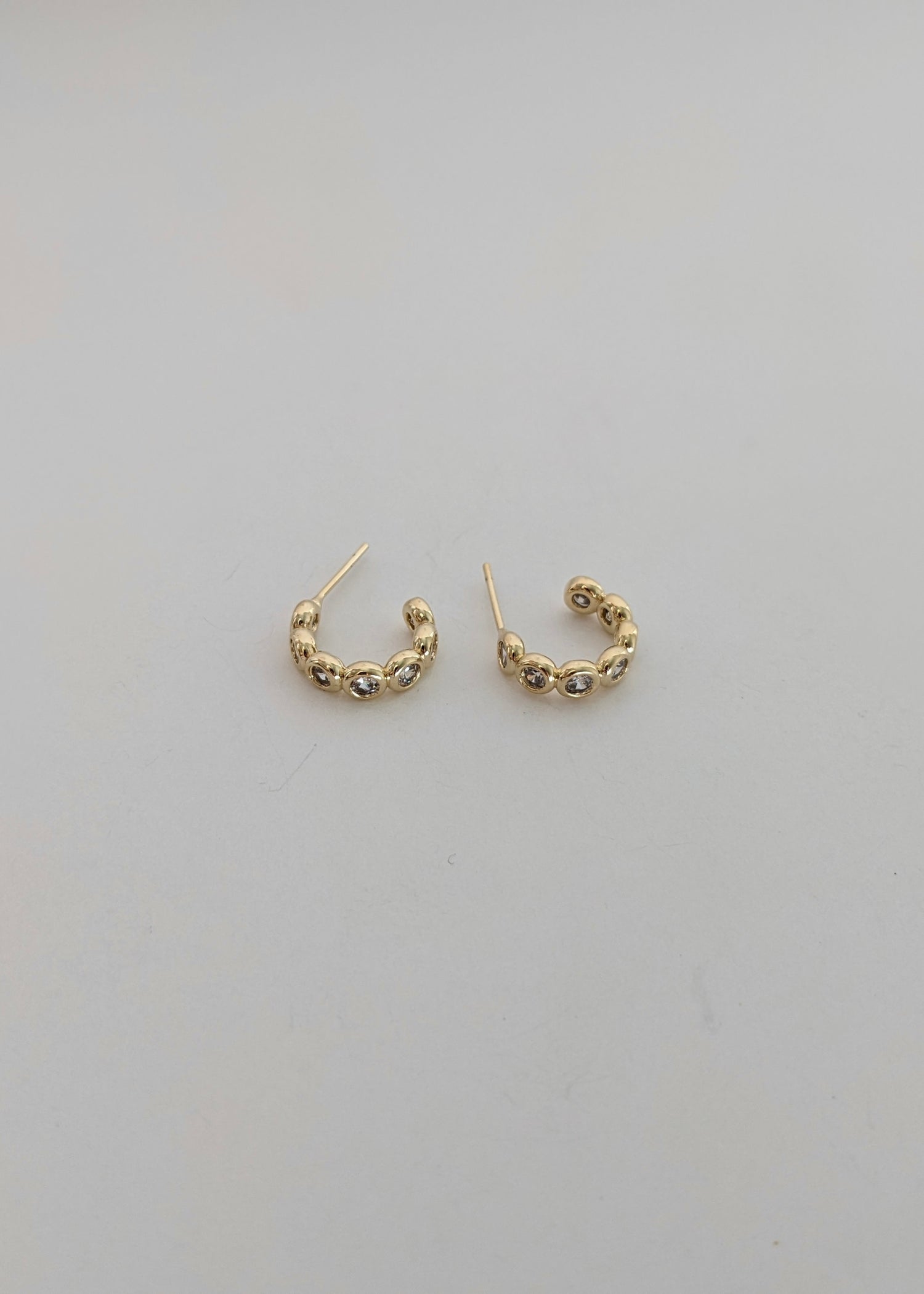 Gold-filled bezel huggie hoops with sparkling cubic zirconia. A comfortable everyday CZ huggie for stacking or wearing solo. Handmade in Brooklyn.