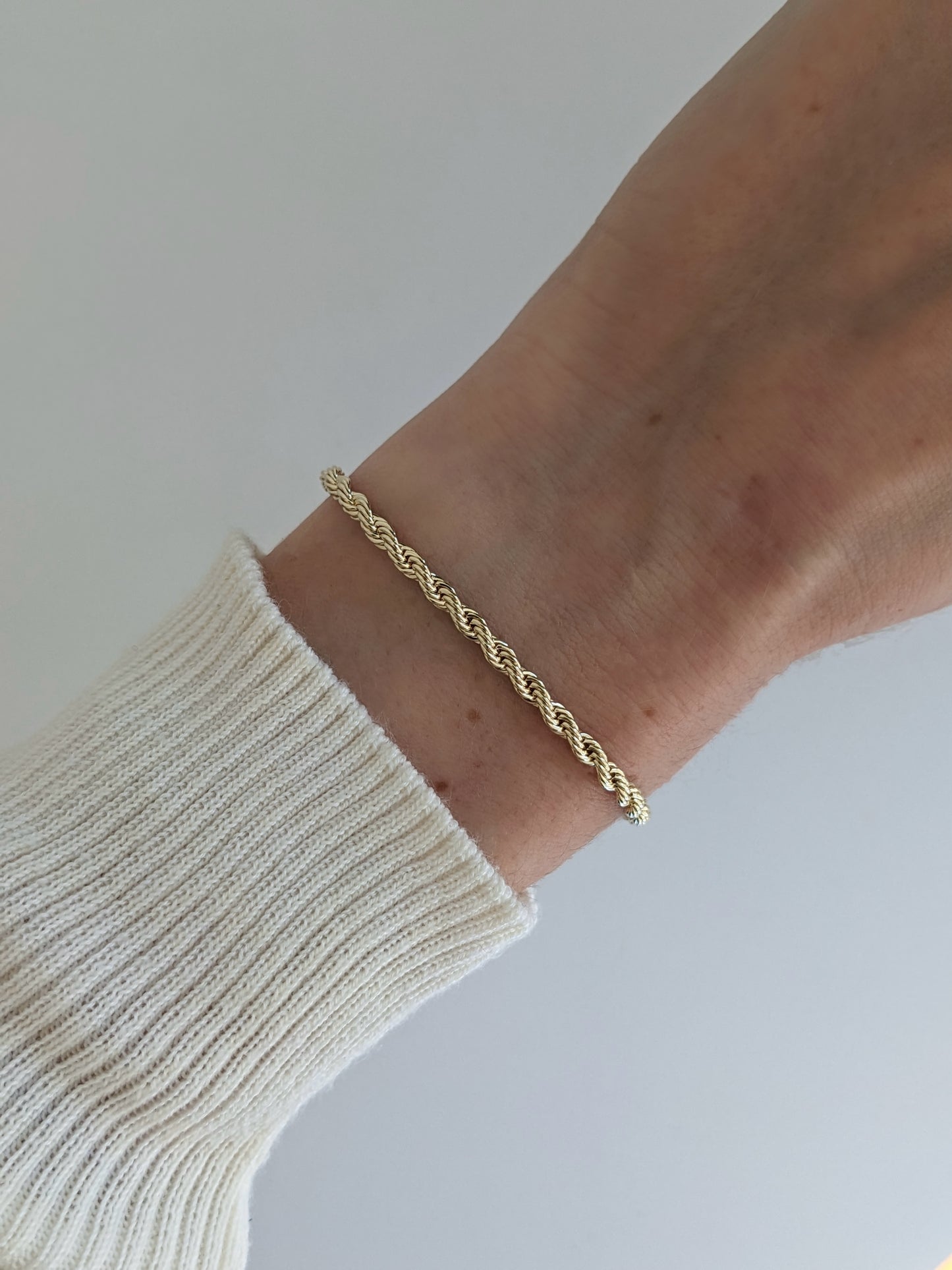Gold filled rope chain bracelet close-up worn on the wrist.
