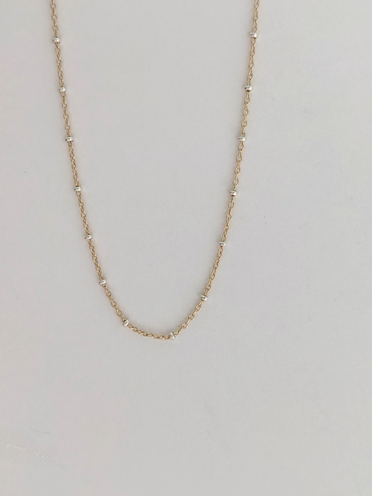 Delicate mixed metal satellite chain necklace in gold-filled and sterling silver. A dainty two-tone layering piece, handmade in Brooklyn by Layer the Love.