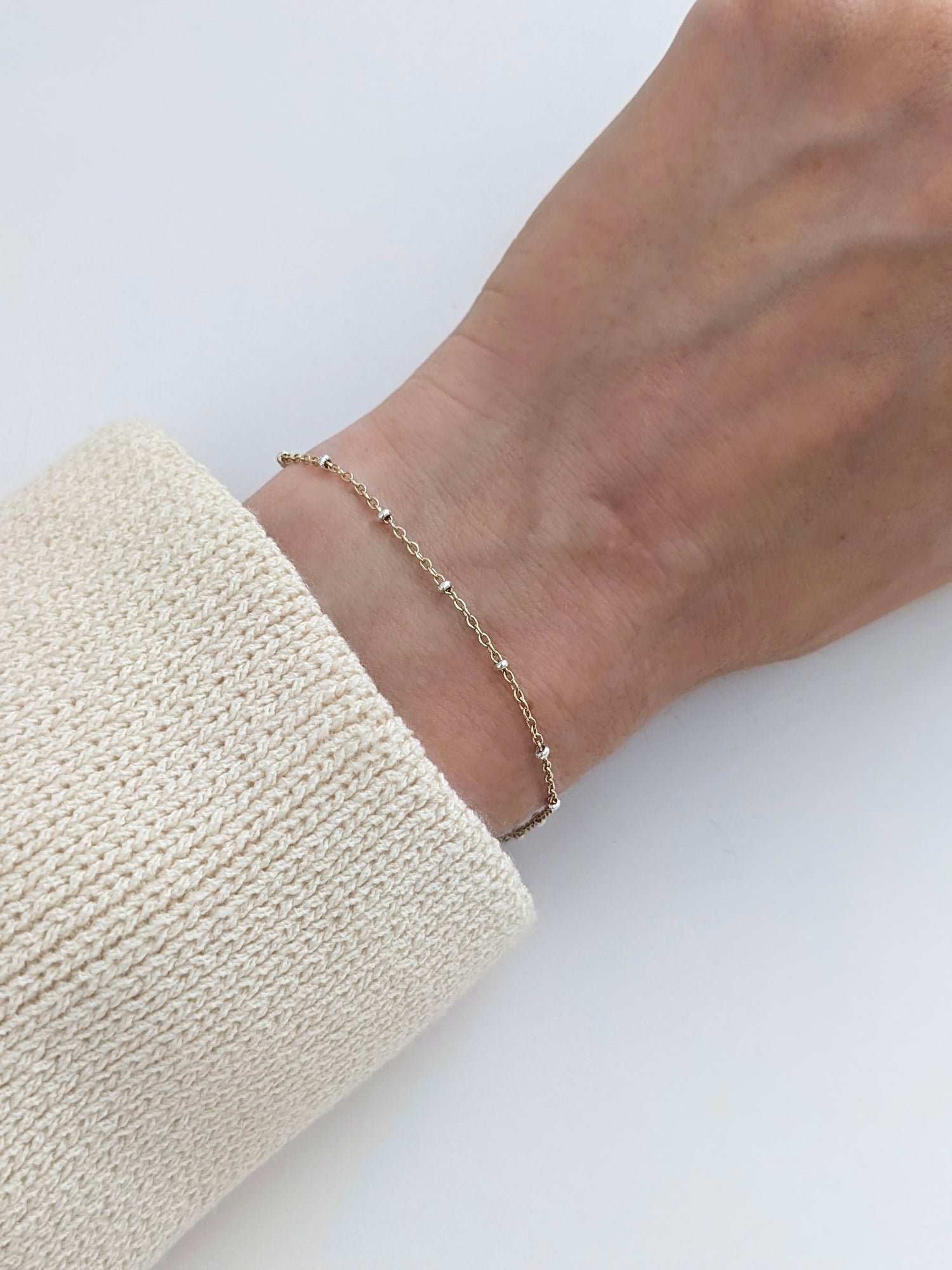 Delicate mixed metal satellite chain bracelet in gold-filled and sterling silver. A dainty two-tone stacking bracelet, handmade in Brooklyn by Layer the Love.